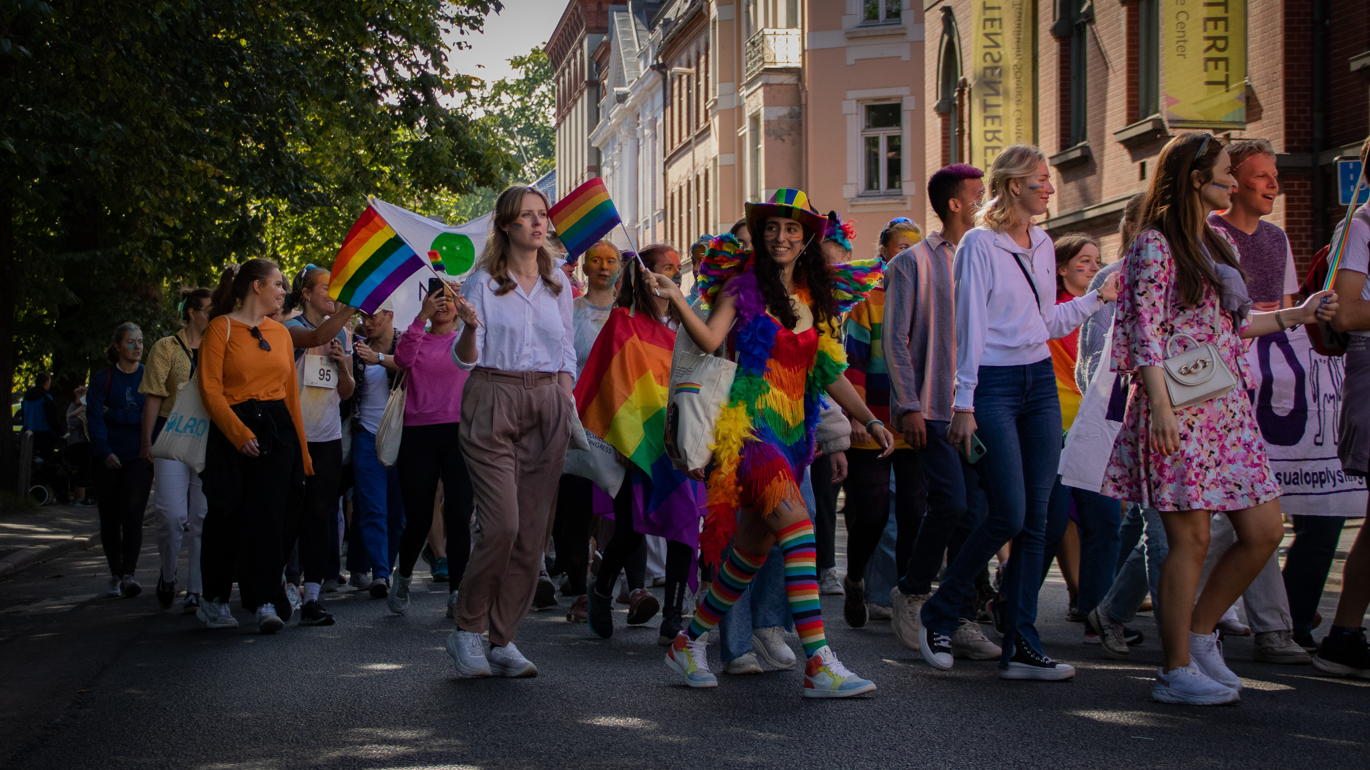 En kvinne som deltar i paraden har kledd seg i regnbuens farger, fra topp til tå.