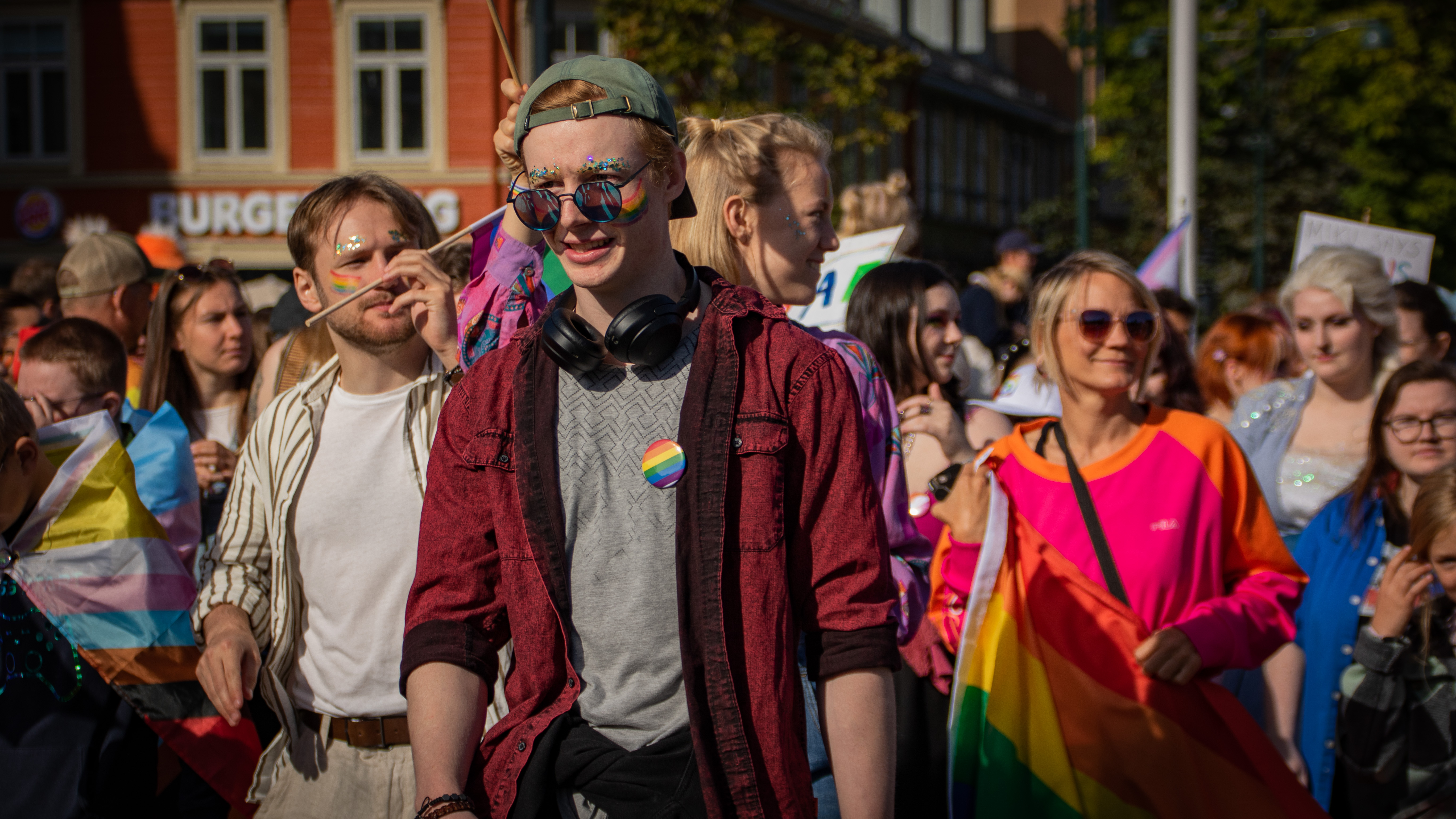 Menn og kvinner, med regnbueflagg, marsjerer inn på torget i Trondheim.