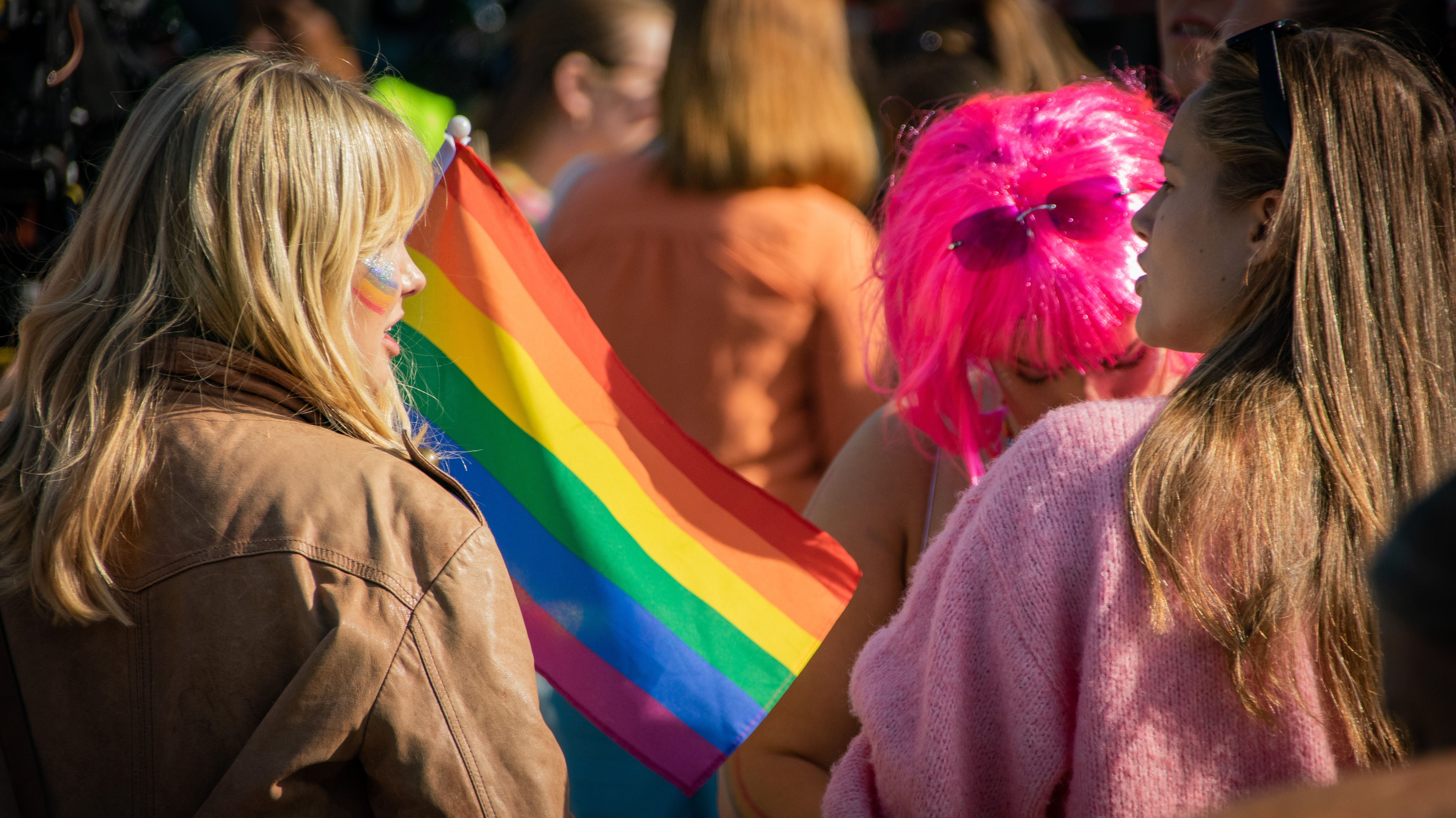 Deltagere på Pride-markeringen har med seg regnbueflagg.
